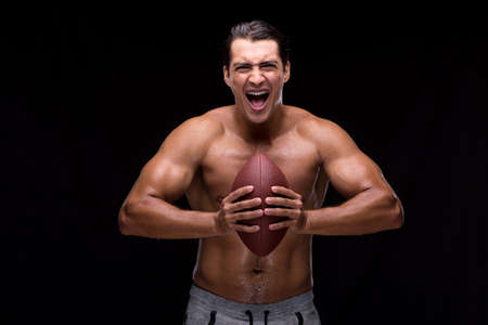 Ripped muscular man with american footballの写真素材