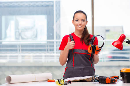 Young woman in coveralls doing repairsの写真素材