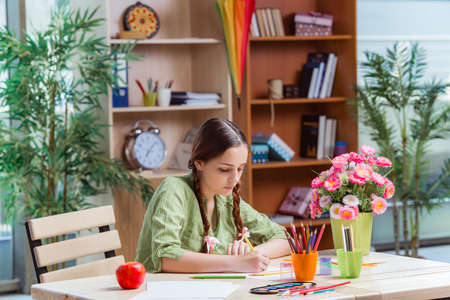Young girl drawing pictures at home