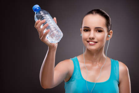 Woman doing sports with bottle of fresh water