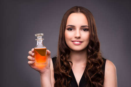 Young woman with bottle of perfume