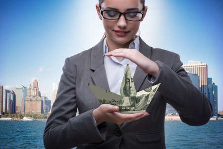 Businesswoman with dollar boats in business conceptの写真素材