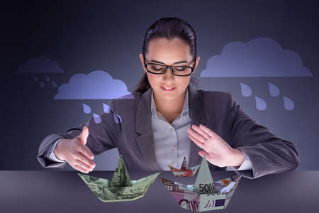 Businesswoman with dollar boats in business conceptの写真素材