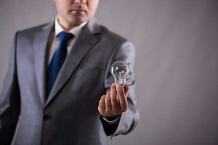 Businessman holding light bulb in creativity concept