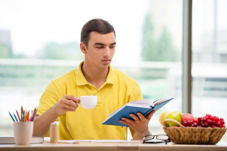 Student reading book and drinking teaの写真素材