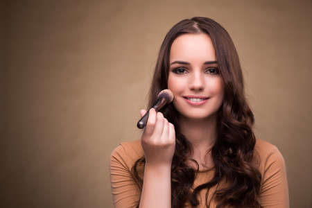 Beautiful woman applying make-up in beauty conceptの写真素材