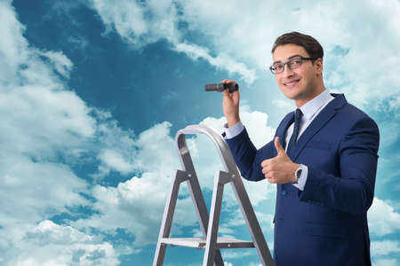 Businessman with binoculars on the stairs ladderの写真素材