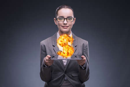 Businesswoman holding burning american dollar signの写真素材