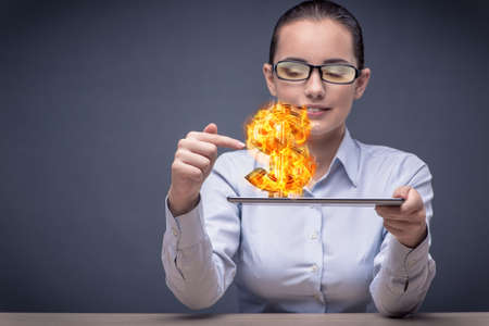 Businesswoman holding burning american dollar signの写真素材