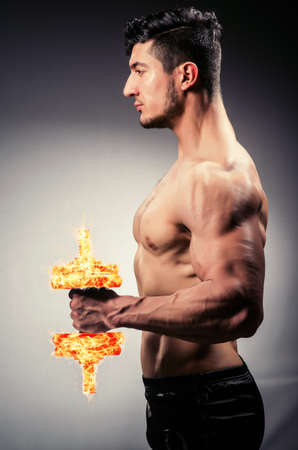 Muscular ripped bodybuilder with burning dumbbellsの写真素材