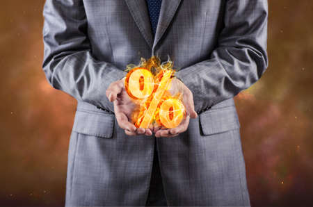 Businessman with percent sign in high interest conceptの写真素材