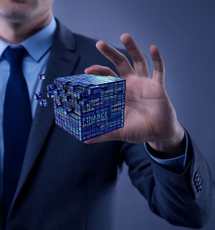 Businessman holding financial cube in business conceptの写真素材