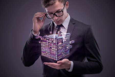Businessman holding financial cube in business concept