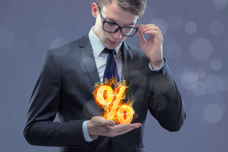 Businessman with percent sign in high interest conceptの写真素材