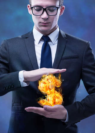 Businessman holding burning american dollar signの写真素材