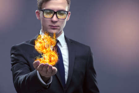 Businessman holding burning american dollar signの写真素材