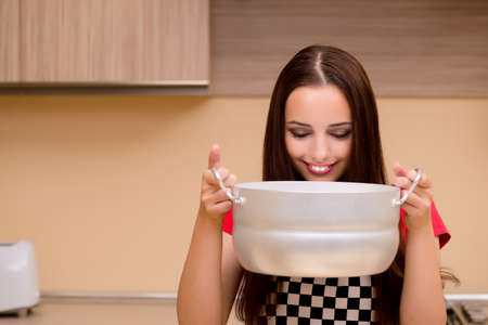 Young woman housewife working in the kitchenの写真素材