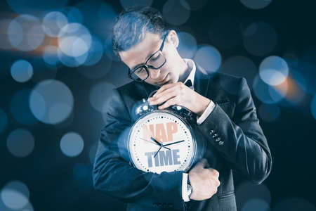 Businessman with clock sleeping in business conceptの写真素材