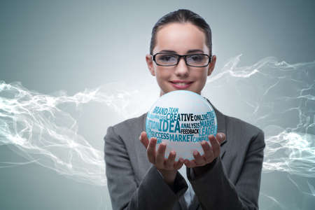 Businesswoman with crystal ball in business conceptの写真素材