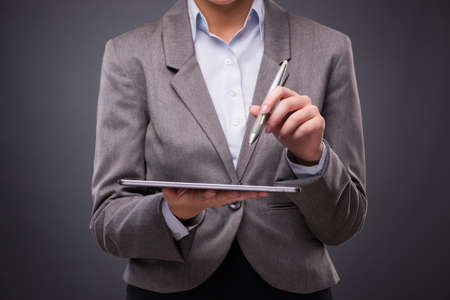 Businesswoman working on tablet computer in business conceptの写真素材