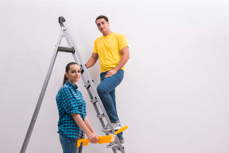 Young couple painting wall at homeの写真素材