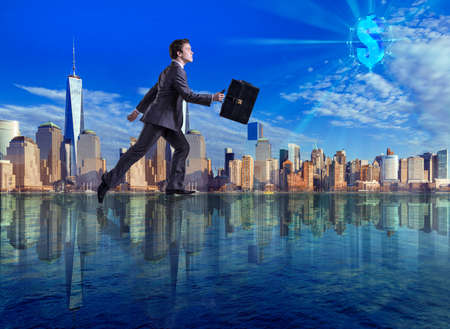 Businessman walking on the water towards dollarの写真素材