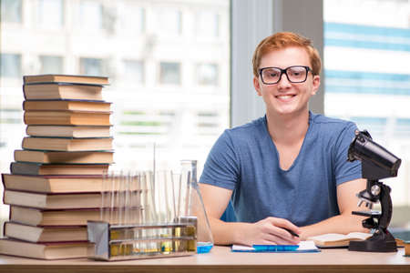 Young student tired and exhausted preparing for chemistry examの写真素材