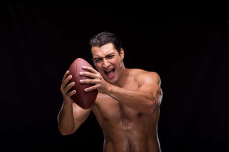Ripped muscular man with american footballの写真素材