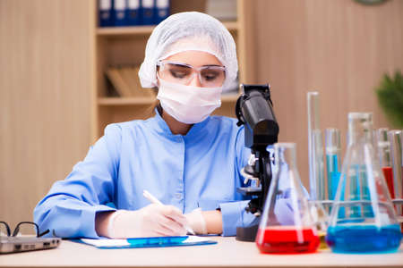 Lab chemist working with microscope and tubes