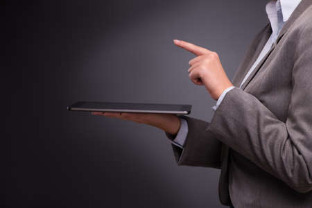 Businesswoman working on tablet computer in business conceptの写真素材