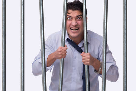 Young businessman behind the bars in prison