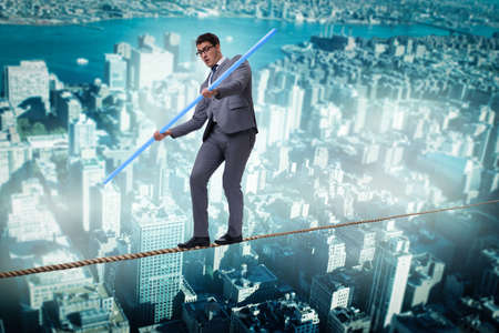 Businessman doing tightrope walking in risk concept