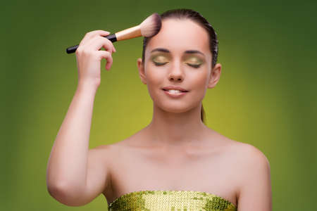Beautiful woman applying make-up in beauty conceptの写真素材