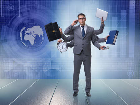 Young businessman in multitasking conceptの写真素材