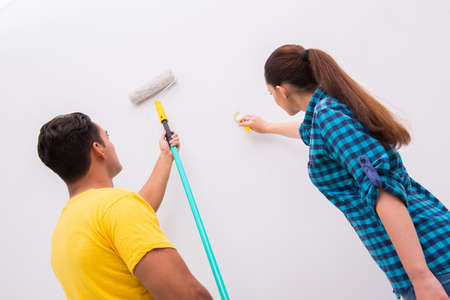 Young couple painting wall at homeの写真素材