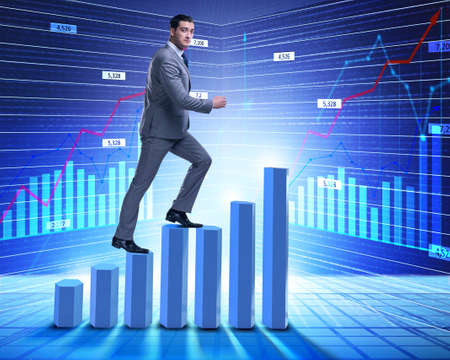 Businessman climbing bar charts in business conceptの写真素材