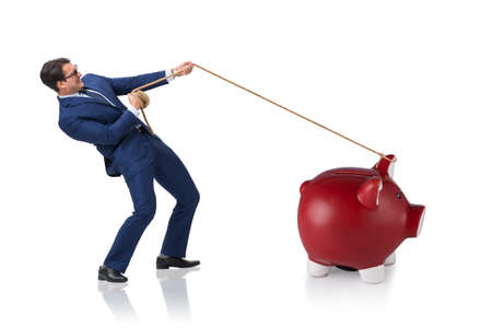 Businessman pulling piggybank with ropeの写真素材