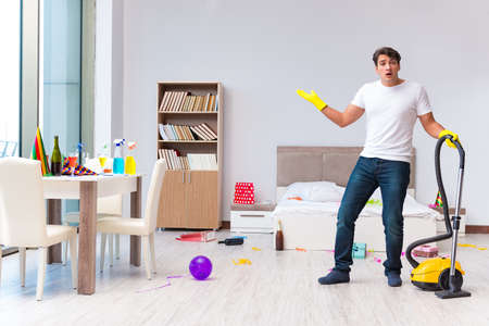 Man cleaning the house after christmas partyの写真素材