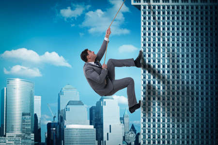 Businessman in challenge concept climbing skyscraper