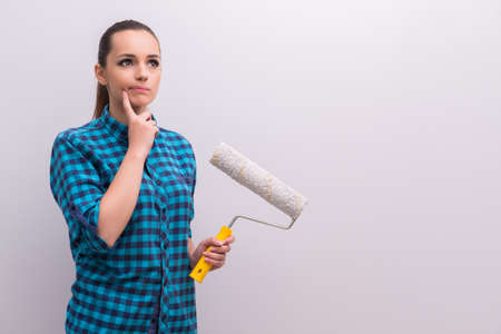 Woman painting house in DIY concept