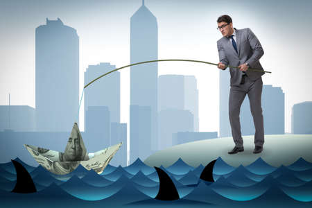 Businessman fishing out dollars from waterの写真素材