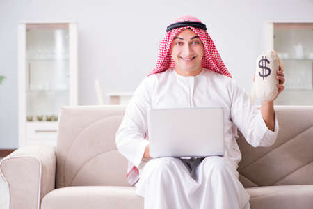 Young arab businessman working with laptop on sofaの写真素材