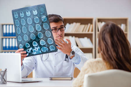 Young doctor looking at computer tomography x-ray imageの写真素材