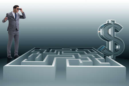 Man trying to reach dollars through mazeの写真素材