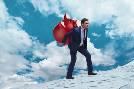 Businessman carrying the piggybank with savingsの写真素材