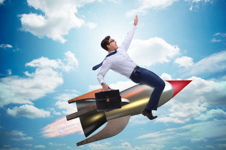 Businessman flying on rocket in business conceptの写真素材