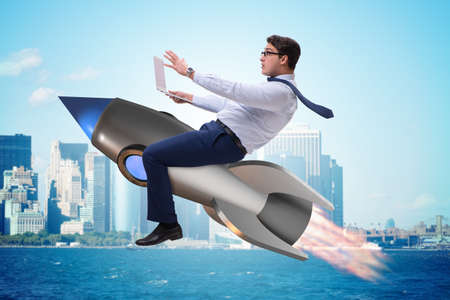 Businessman flying on rocket in business conceptの写真素材