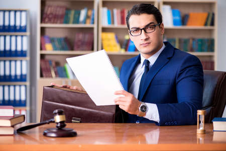 Handsome judge with gavel sitting in courtroomの写真素材