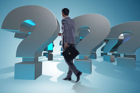 Businessman in uncertainty concept with question marksの写真素材