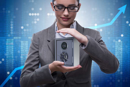 Businesswoman holding metal safe in security conceptの写真素材